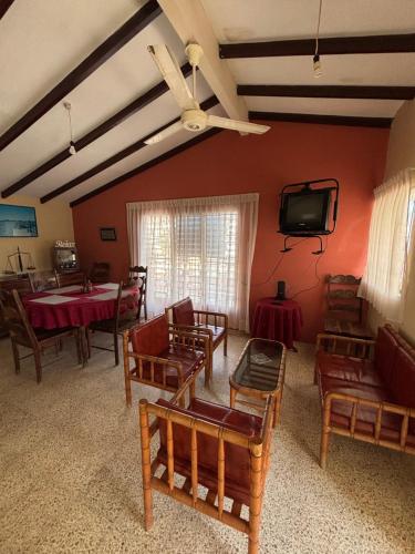 a living room with tables and chairs and a tv at Casa La Marina Salinas Beach in Salinas
