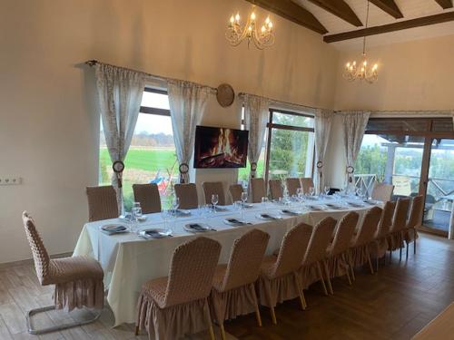 a large dining room with a long table and chairs at Sodyba Gintaras in Priekulė
