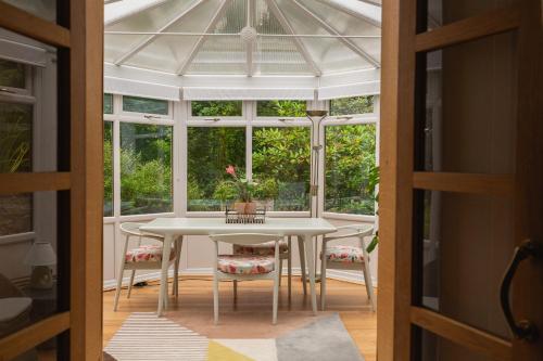 a conservatory with a table and chairs and a window at The Coach House in Stirling