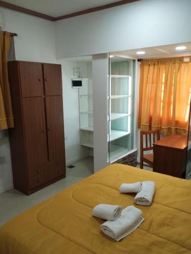 a bedroom with a bed with two towels on it at La posada de Norma in Capilla del Monte
