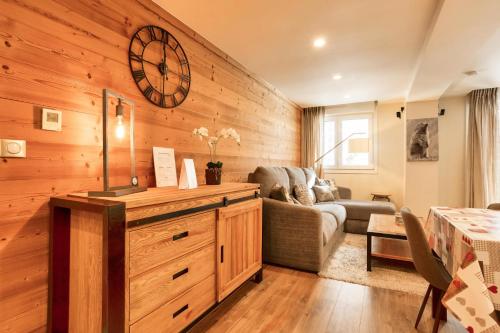 un salon avec un canapé et une horloge au mur dans l'établissement Résidence les Chardons - maeva Home - Appartement chaleureux 4 pièces 8 personnes - Prestige - super Home MAE-3341, à Arc 1800