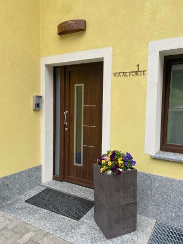 a front door of a building with a planter with flowers at Residence S Lucia - Appartamenti alle porte di Bormio in Valdisotto
