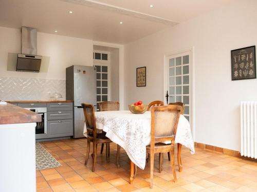 a kitchen with a table with chairs and a kitchen with a refrigerator at La maison de famille gîte classé 4 étoiles in Luçon