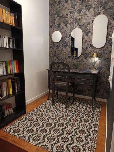 a dining room with a table and a mirror at La maison de famille gîte classé 4 étoiles in Luçon