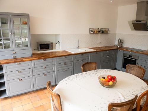 a kitchen with a table with a bowl of fruit on it at La maison de famille gîte classé 4 étoiles in Luçon