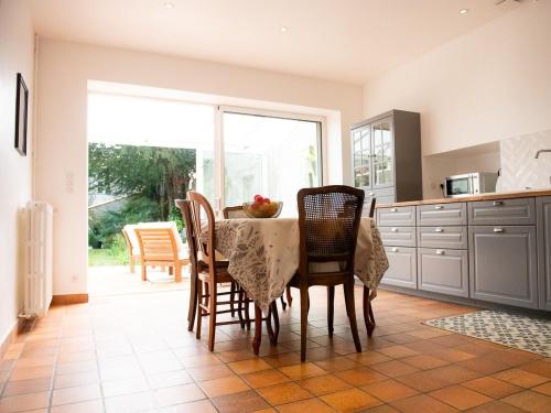 a kitchen with a table with chairs and a table and a window at La maison de famille gîte classé 4 étoiles in Luçon