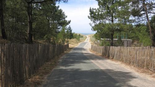 an empty road with a fence and a wooden at La maison de famille gîte classé 4 étoiles in Luçon