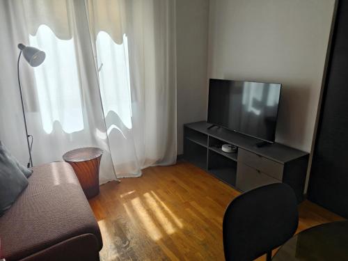 un soggiorno con divano e TV a schermo piatto di Fluère - Via Riva Reno a Bologna