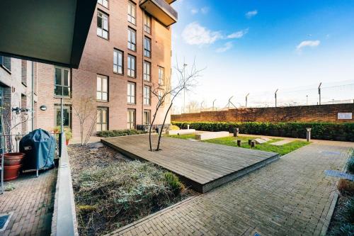 a tree sitting on a wooden deck in front of a building at Peaceful Apartment in East End in London