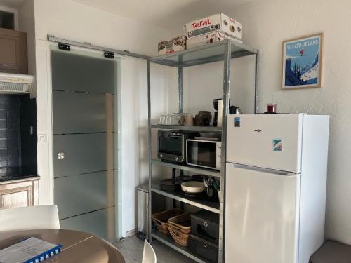 a kitchen with a white refrigerator and a table at Au pied des pistes Côte 2000 - Le Balcon de Villard de Lans in Villard-de-Lans
