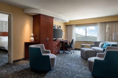 a hotel room with a bed and a desk and chairs at Courtyard by Marriott Glenwood Springs in Glenwood Springs