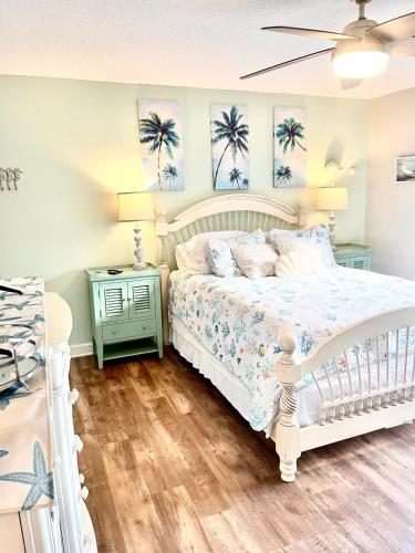 a bedroom with a white bed and two palm trees at The Blue Crab in Myrtle Beach