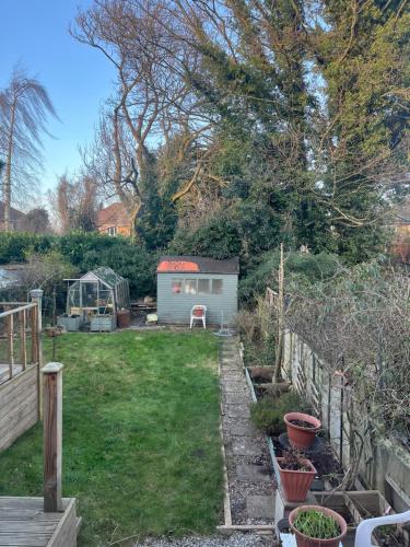 a garden with a small shed in a yard at Tiny house with pull down bed in Cottingham