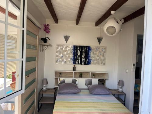 a bed in a small room with a window at LA PAILLOTE D OR in Sainte-Anne