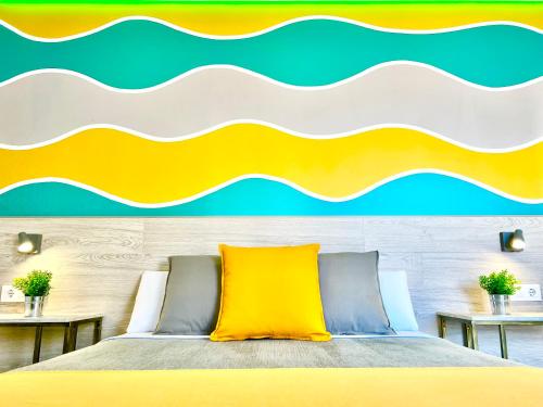 a bedroom with a bed with a yellow pillow at DORI ROOMS - Hostal in Tarifa