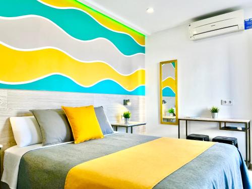 a bedroom with a bed with a painting on the wall at DORI ROOMS - Hostal in Tarifa