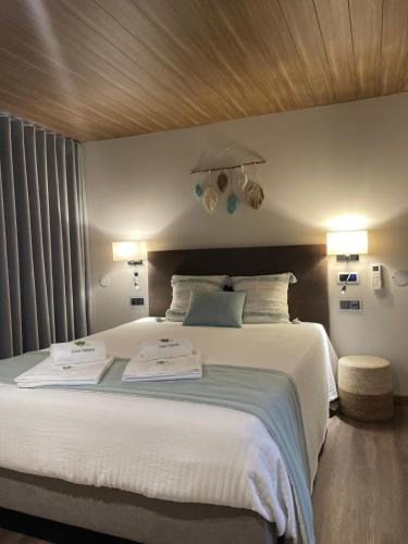 a bedroom with a large bed with two towels on it at Casa Videira in Gouveia