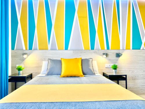 a bedroom with a bed with a yellow pillow at DORI ROOMS - Hostal in Tarifa