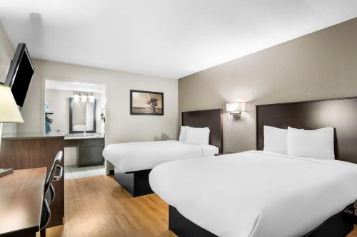 a hotel room with two beds and a mirror at Rodeway Inn in Waco