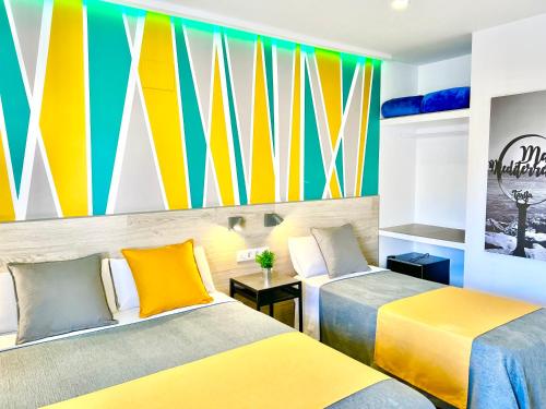 two beds in a room with a colorful mural at DORI ROOMS - Hostal in Tarifa