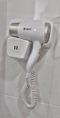 a white phone is hanging on a wall at Suites em Jabaquara, Paraty in Paraty