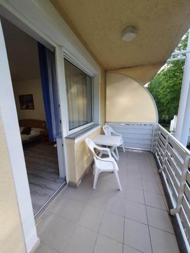 a balcony with a table and chairs on it at Arizona apartman in Siófok