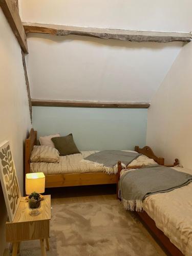 a bedroom with two beds and a table with a chair at Bourlidou in Combourg