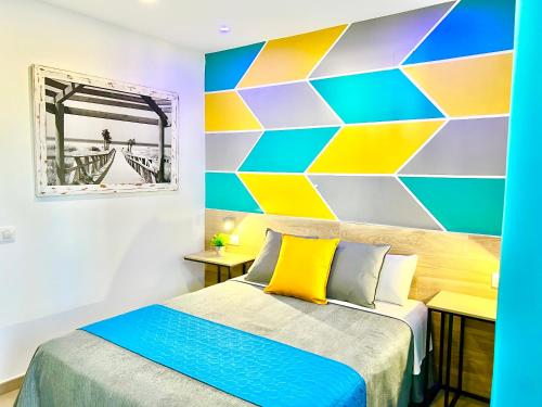 a room with a bed and a colorful wall at DORI ROOMS - Hostal in Tarifa