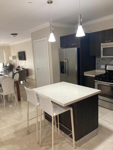 a kitchen with a white table and white chairs at Aruba Stop by The Stop Club in Palm-Eagle Beach