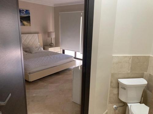 a small bathroom with a bed and a toilet at Aruba Stop by The Stop Club in Palm-Eagle Beach