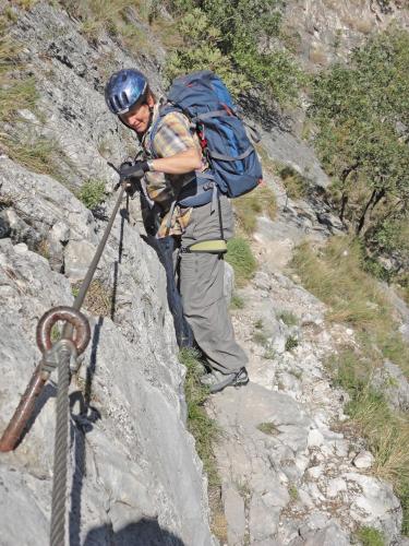 a man with a backpack standing on a rocky trail at Ferienwohnung Maderno in Affoltern