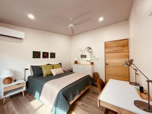 a bedroom with a bed and a desk and a table at Casa Tres Luces - Samara Home in Nicoya