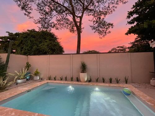 a swimming pool in a backyard with a fence at Casa Tres Luces - Samara Home in Nicoya