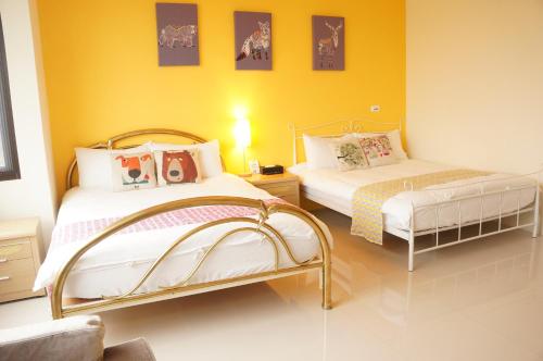 1 dormitorio con 2 camas y pared amarilla en Lucky Smith B&B, en Jian