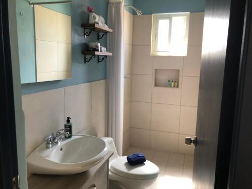 a bathroom with a sink and a toilet at Aruba IXORA Suites in Noord