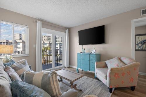 a living room with a couch and a tv at Plantation East #2212 in Gulf Shores