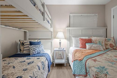a bedroom with two beds and a staircase at Plantation East #2212 in Gulf Shores