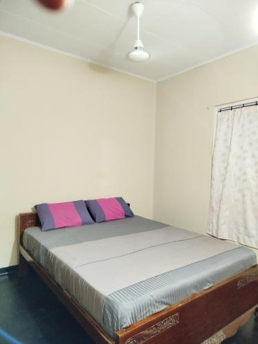 a bed sitting in a room with a window at Holy Spirit Mission Camps in Mount Lavinia