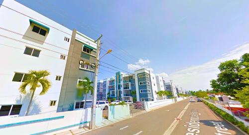 an empty city street with buildings and palm trees at Escapade tropicale in Santiago de los Caballeros
