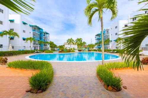 a swimming pool with palm trees and buildings at Escapade tropicale in Santiago de los Caballeros
