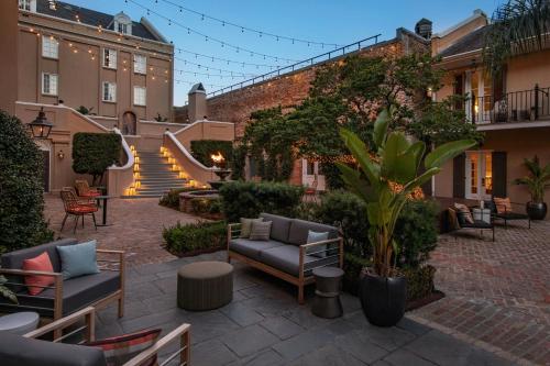 a courtyard with couches and chairs and a staircase at Hotel de la Poste - French Quarter, A Renaissance Hotel in New Orleans