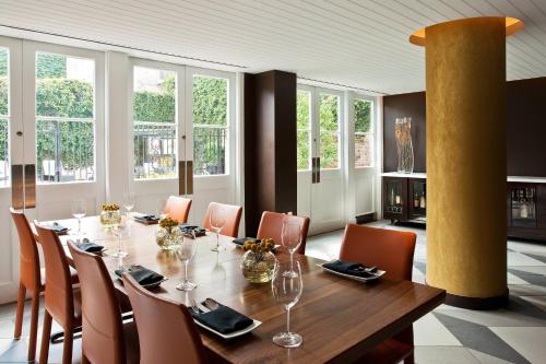 a dining room with a table and chairs and windows at Hotel de la Poste - French Quarter, A Renaissance Hotel in New Orleans