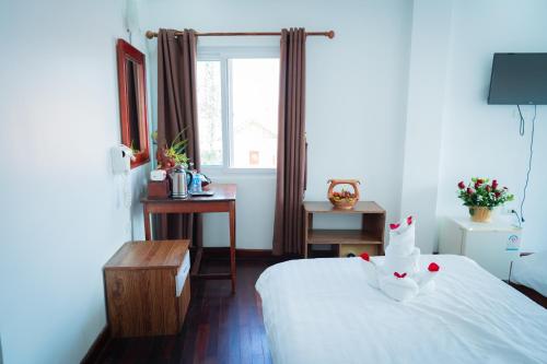 a bedroom with a white bed and a window at Vientiane Ruby Riverside Hotel in Vientiane