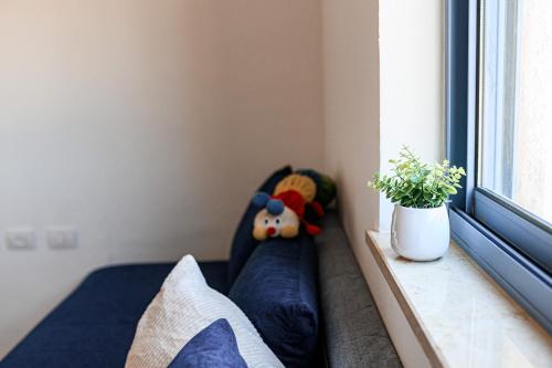 a bedroom with a couch with a stuffed animal in a window at אתנחתא- צימר משפחתי - Etnachta- A family hosting unit in Yeroẖam