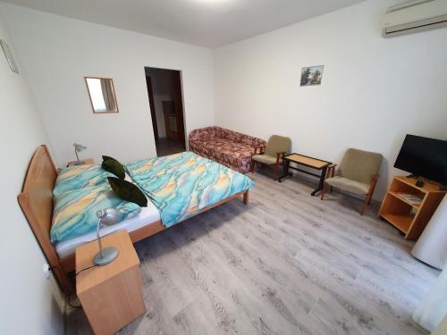a bedroom with a bed and a living room with a couch at Arizona apartman in Siófok