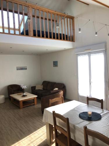 un salon avec une table et un canapé dans l'établissement Charmante maison proche Wimereux, à Wimille