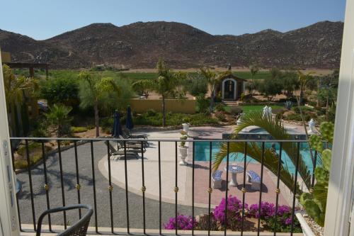 a view from the balcony of a resort with a pool at Palazzo del Valle, Alojamiento y Desayuno in Valle de Guadalupe
