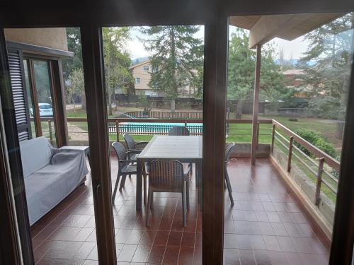 a screened in porch with a table and chairs at Chalet ideal para grupos familiares y grupos de adultos in Sant Juliá de Vilatorta