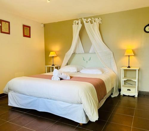 - une chambre avec un grand lit blanc à baldaquin dans l'établissement Gîte Les Jardins de Terrefort, à Saumur