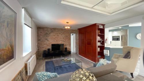 a living room with a couch and a tv at Quebec Grand Appartement by Hébergements DCL in Quebec City